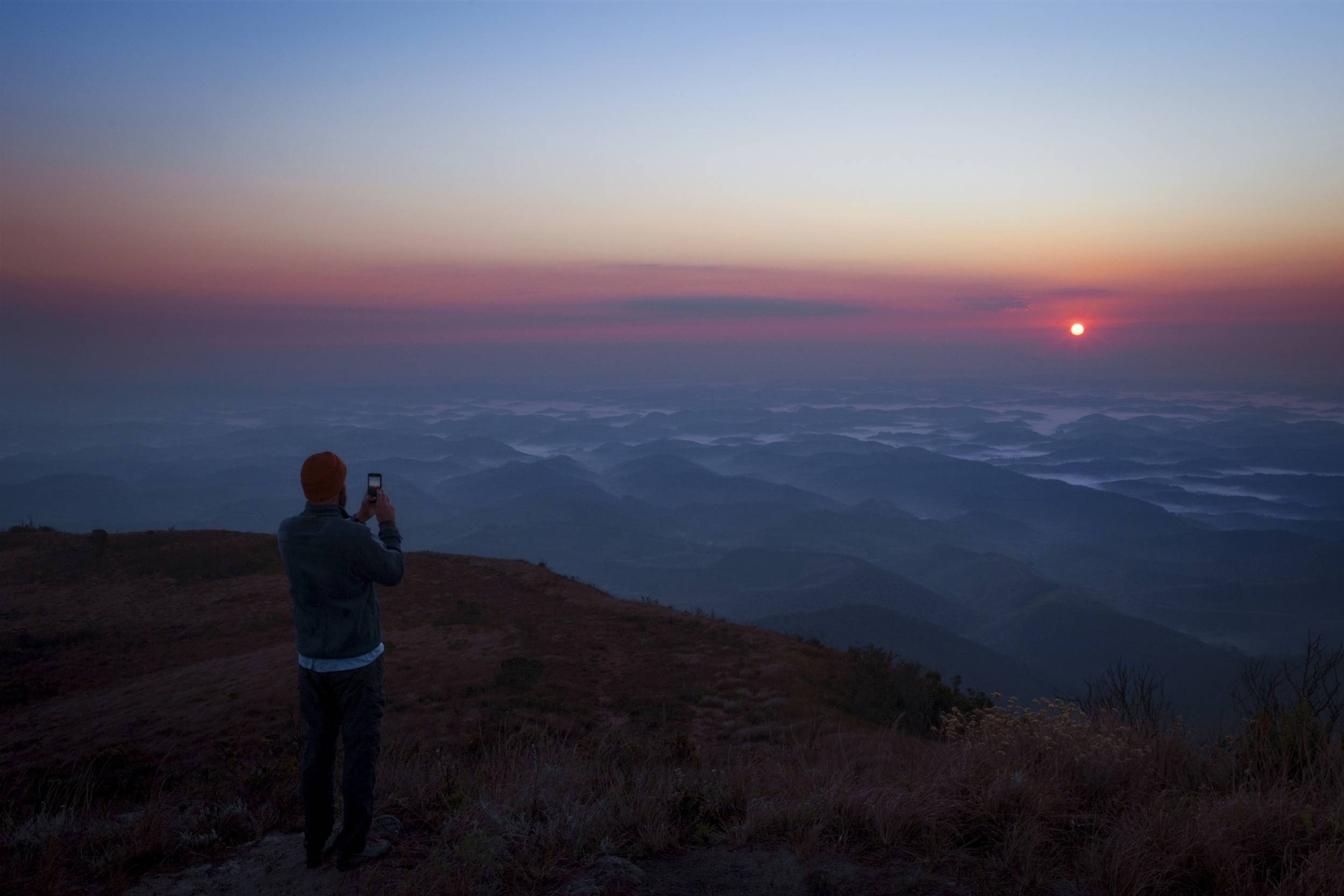 En man fotograferar solnedgången